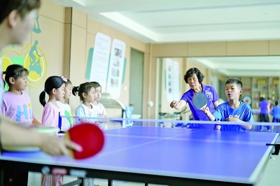 孩子们在“爱心暑托班”上学习打乒乓球